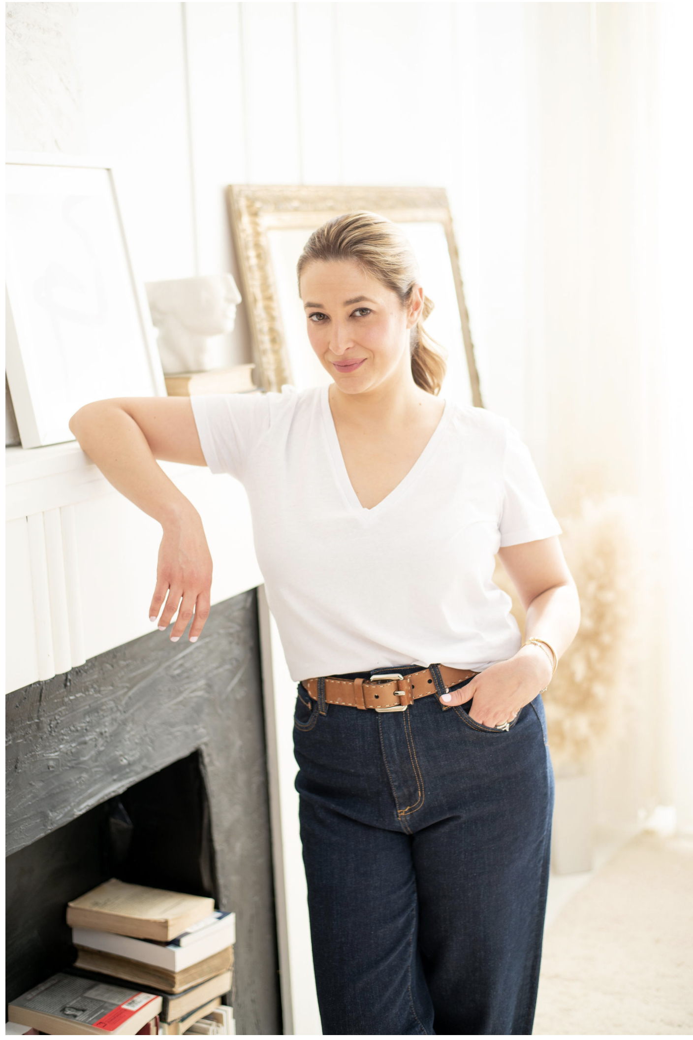 Copywriter and marketing strategist Laura Gatsos Young stands in front of a fireplace